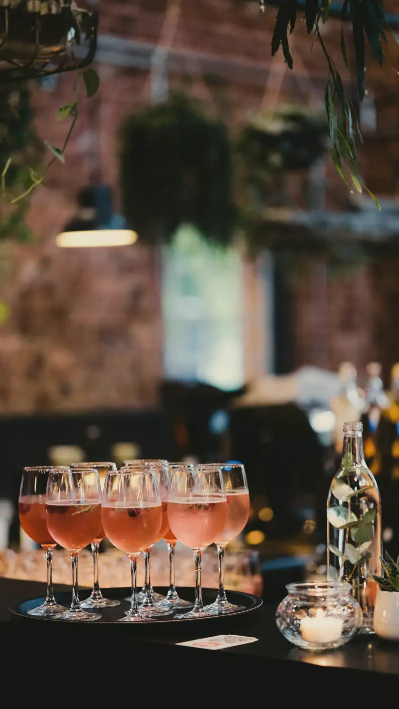 Fileira de taças com drink rosé prontas para servir em um evento